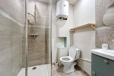 a bathroom with a toilet and a glass shower at Charming studio near the city center of Narbonne in Narbonne
