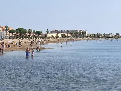 a group of people standing in the water at a beach at Gruissan - T2 Mezzanine Climatisé - 6 Pers - Parking Proche Plage - FR-1-796-87 in Gruissan