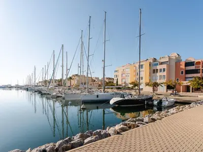 a row of boats docked in a harbor with buildings at Studio cabine avec terrasse, animaux admis, pour 4 personnes - FR-1-409A-33 in Gruissan
