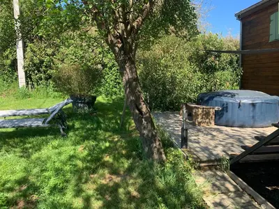 a tree and a tub sitting next to a house at La roulotte de Plajoulet in Mirepoix