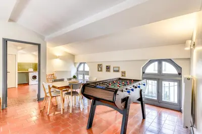 a living room with a foosball table in the middle of a room at Cocon Carcassonnais - Free parking - Wifi - Climatisation - Tout équipée in Carcassonne