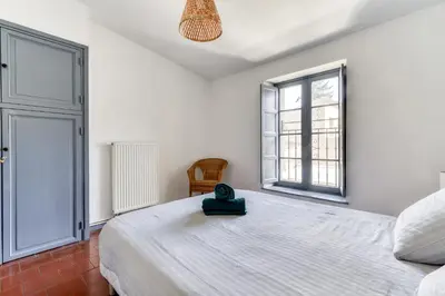 a bedroom with a large bed and a window at Cocon Carcassonnais - Free parking - Wifi - Climatisation - Tout équipée in Carcassonne