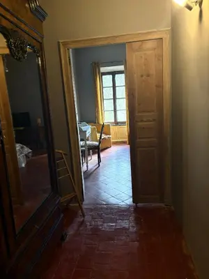 a hallway with a door and a mirror and a table at O'MAZETTE CHAMBRE D'HOTE ROMANTIQUE visite de l'aude in Fabrezan