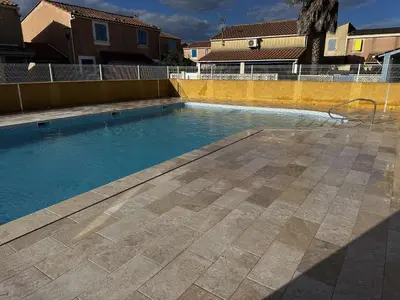 a swimming pool with blue water in a yard at Pavillon Bora Bora, 2 salles d eau et piscine - GA090-002 in Gruissan