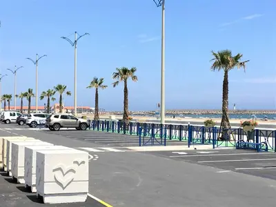 a parking lot at the beach with palm trees at Appartement 2 pièces PORT LA NOUVELLE PN015-003 in Port-la-Nouvelle