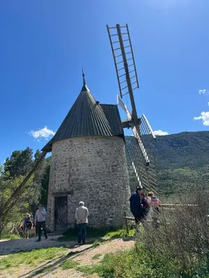 a group of people standing around a windmill at Suite Noire et Blanche in Saint-Paul-de-Fenouillet
