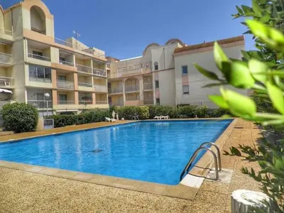 a large swimming pool in front of a building at Appartement climatisé, vue sur le port technique - GN160-331 in Gruissan