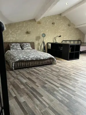 a bedroom with a bed and a dresser at Maison loft au cachet ancien in Villasavary
