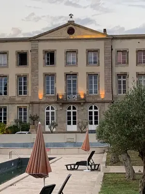a large building with two umbrellas in front of it at La Redorte 17 in La Redorte