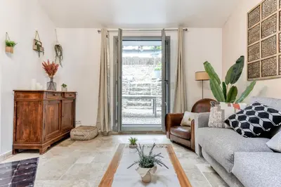 a living room with a couch and a table at Au Pied de la Cité - Terrasse - Climatisation - Wifi in Carcassonne