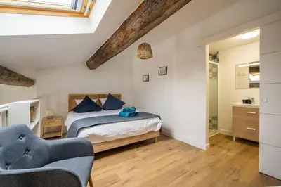a bedroom with a bed and two chairs at Le Chenal - Appartement Duplex proche des halles in Narbonne