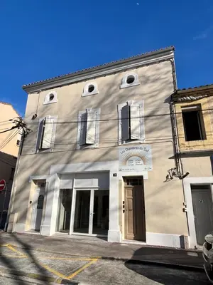 a gray building with windows on a street at La Saphir in Narbonne
