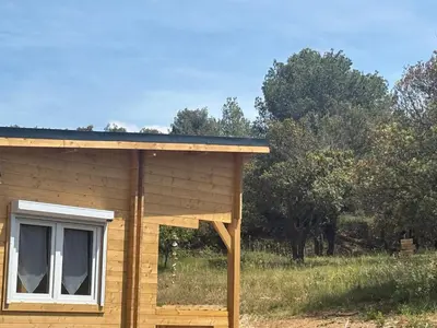 a log cabin with a window and a roof at Chalet Chêne-Pin in Boutenac