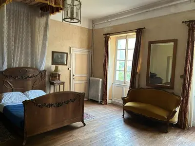 a bedroom with a bed and a chair and a window at Château Belle au Bois Dormant in Cambounet-sur-le-Sor