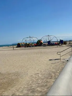 a beach with a roller coaster in the background at Charmant T2 à 1 min de la plage in Port-la-Nouvelle