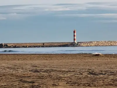 a lighthouse sitting on the beach with the ocean at Bel appartement proche de la mer in Port-la-Nouvelle