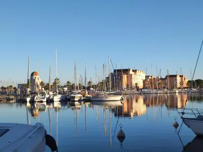 a group of boats docked in a harbor with buildings at Le Thalassa I in Gruissan