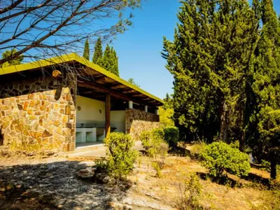 a stone house with a yellow roof at Mobil-home confortable avec terrasse - API-1-52-652 in Lézignan-Corbières