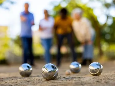 four silver balls sitting on the ground with people in the background at Mobil-home confortable avec terrasse - API-1-52-652 in Lézignan-Corbières