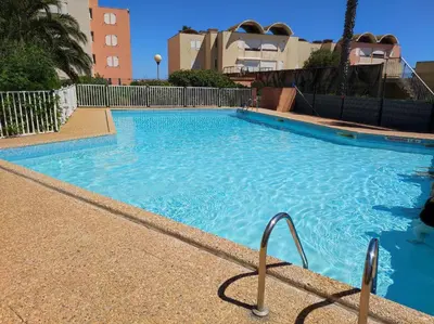 a large blue swimming pool in a building at Le Thalassa II in Gruissan