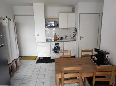 a kitchen with a table and chairs in a kitchen at Le Thalassa II in Gruissan