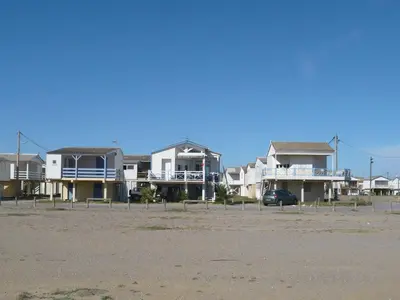 a row of houses on the beach with a car at Holiday Home Bora Bora 2-3 by Interhome in Gruissan