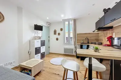 a kitchen with a table and chairs in a room at Charming studio in the city center of Narbonne in Narbonne