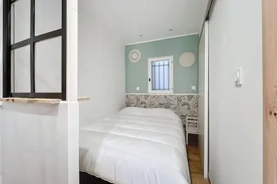 a small bedroom with a bed and a window at Charming studio in the city center of Narbonne in Narbonne