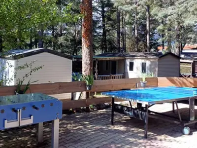 a ping pong table in a backyard with a trailer at Mobil-home confortable avec terrasse à Sournia - API-1-52-358 in Sournia