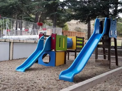 a playground with a slide in a park at Mobil-home confortable avec terrasse à Sournia - API-1-52-358 in Sournia