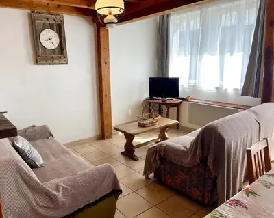 a room with two beds and a table with a clock on the wall at Maison accueillante à Le Soulié avec jardin in Le Soulié