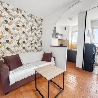 a living room with a couch and a table at Studio Cabine En Bord De Mer à Gruissan in Gruissan