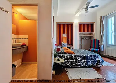 a bedroom with a bed and a sink in it at La Maison Bleue de Sigean - Loft 2 in Sigean