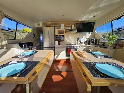 an rv kitchen with two tables with wine glasses at BATEAU NAVYLIS Croisière in Capestang