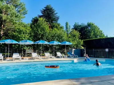 two people in a swimming pool with umbrellas at Bungalow 3 Pièces avec Terrasse - API-1-52-888 in Camon