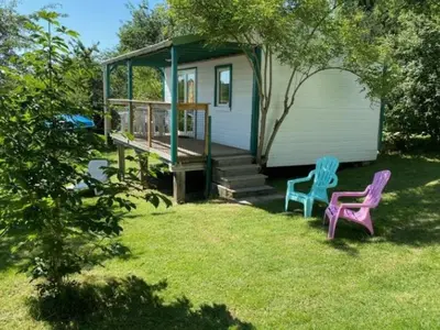 two chairs sitting in the grass in front of a house at Mobil-home confortable avec terrasse au calme - API-1-52-915 in Camon
