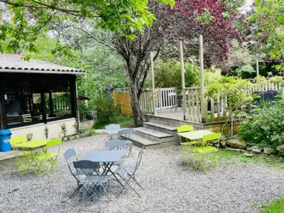 a group of tables and chairs in a garden at Chalet 8 pers avec Terrasse - API-1-52-1027 in Camon