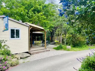 a small white building with a gazebo at Chalet Confort 6 Pers - Terrasse - API-1-52-1032 in Camon
