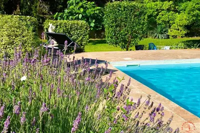 a person sitting in a chair next to a pool at Gîte Jardin in Narbonne