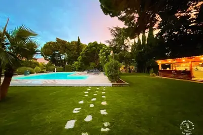 a yard with a swimming pool and green grass at Gîte Jardin in Narbonne