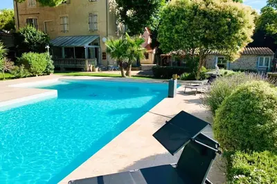 a swimming pool in front of a house at Gîte Jardin in Narbonne