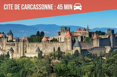 a large castle on a hill with mountains in the background at Gîte Studio Les Cigales piscine & WIFI in Narbonne