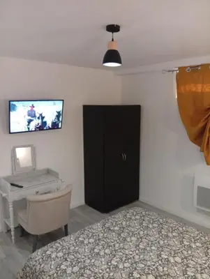 a bedroom with a bed and a desk and a tv at Grand logement en souplex entier in Castres