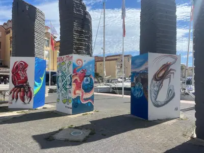 a group of pillars with paintings on them at Gruissan : T2 Climat. et Parking Proche Village - FR-1-796-96 in Gruissan