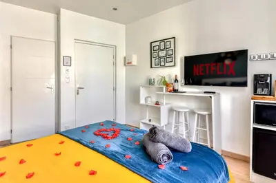 a room with a bed with red flowers on it at Le Bourget - Suite et Envolée romantique avec Jacuzzi in Narbonne