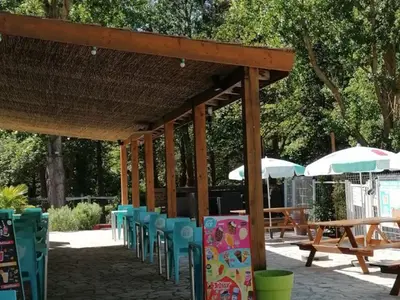 a group of chairs and tables and umbrellas at Mobil-home 2 pers. avec terrasse à Axat - API-1-52-1188 in Axat