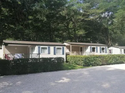 a row of mobile homes parked next to a road at Mobil home avec Terrasse, 2 Chambres, 5 Personnes - API-1-52-1140 in Axat