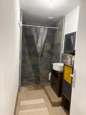 a bathroom with a shower with a shower curtain at Ma petite chaumière in Bouilhonnac