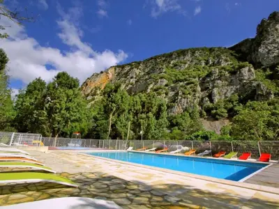 a swimming pool with a mountain in the background at Bungalow toilé avec terrasse jusqu'à 5 personnes - API-1-52-1480 in Axat