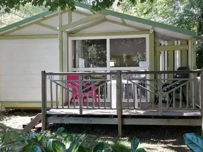 a screened in porch with a pink chair on a deck at Mobil home 21m² avec terrasse à Axat - API-1-52-1082 in Axat